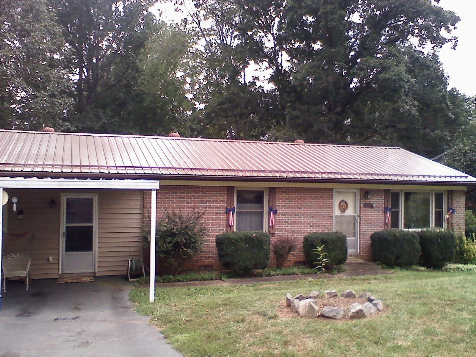 Bronze metal roof and carport on a brick ranch home — Roof Repair work by our crew in Jasper